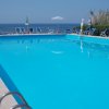 Piscina con vista sull'oceano e sedie a sdraio.