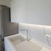 Cucina moderna con mobili bianchi e lavabo.