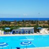 Piscina con vista sul mare e ombrelloni.