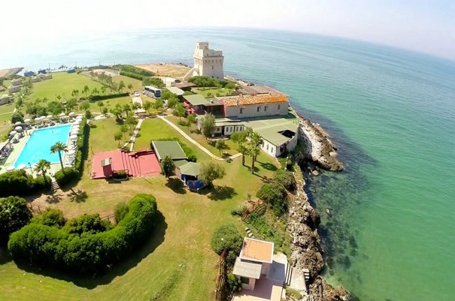 Vista aerea di un complesso sulla costa con piscina.