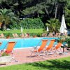 Piscina all'aperto circondata da lettini e ombrelloni.