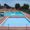Due piscine all'aperto con lettini gialli allineati su una terrazza.