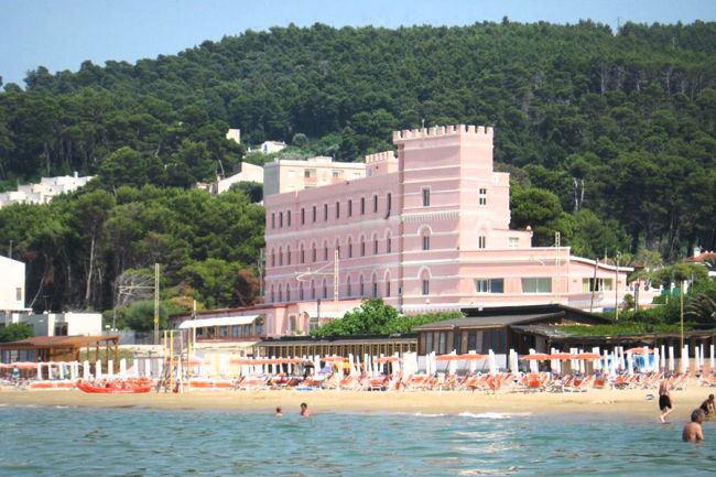 Edificio rosa con torrette vicino alla spiaggia.