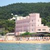 Edificio rosa con torrette vicino alla spiaggia.