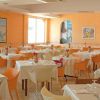 Ristorante luminoso con sedie colorate e tavoli apparecchiati.