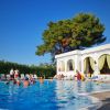 Persone in piscina vicino a un edificio bianco.