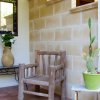 Veranda con sedia in legno, tavolino con vaso di fiori e cactus in un vaso verde.